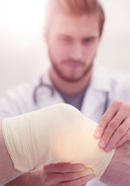 Traumatologist examining the bandage on his kneethe concept of medical care