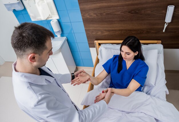 Traumatologist examining patient hands in modern hospital