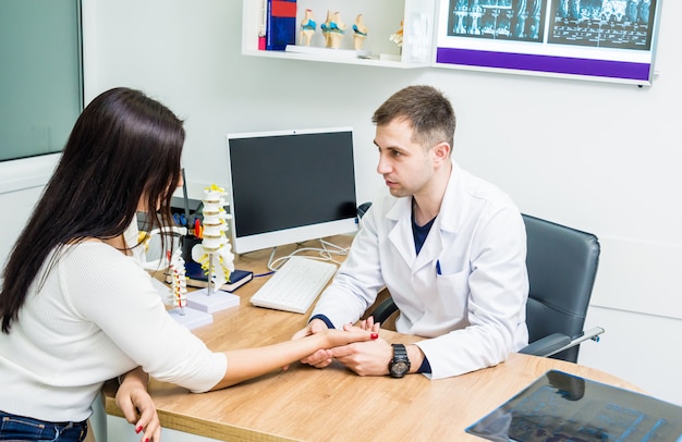 Traumatologist examining patient hands in modern hospital