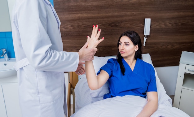 Traumatologist examining patient hands in modern hospital