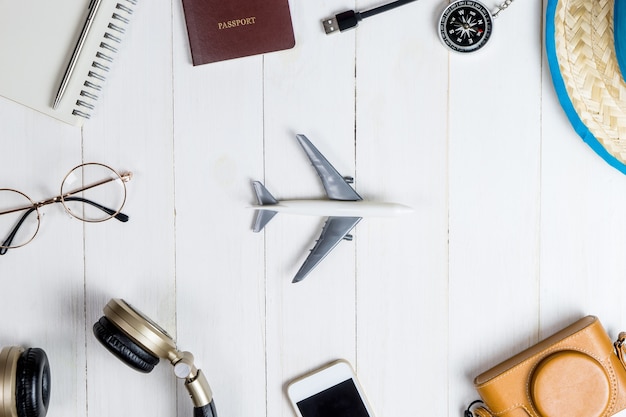 Accessori da viaggio e gadget su whtie in legno con toy plane