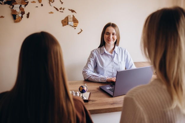 The travel agent keeps tickets for the plane in the travel agency She offers them to clients Couple at the travel agency office prepairing for a summer vacation Concept for travel agent