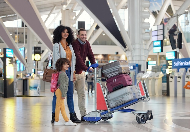 Photo travel airport and happy family with suitcase trolley for holiday vacation or immigration journey luggage of black woman or diversity parents with child or kid walking in lobby excited for flight