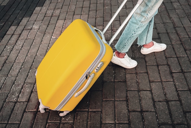 Travel. airport. woman with yellow suitcase