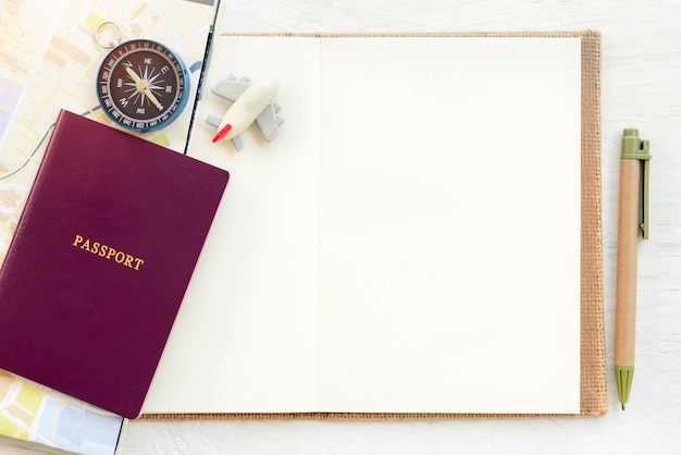 Foto concetto di sfondo di viaggio. passaporto con aereo e bussola messi su carta bianca vuota per te