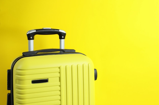 Photo travel bag on yellow background, space for text