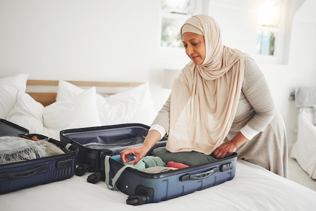 Camera da letto da viaggio e donna musulmana con valigia che fa i bagagli per le vacanze e il viaggio religioso bagagli domestici e persona di sesso femminile islamico con vestiti in borsa si preparano per il viaggio avventura e turismo