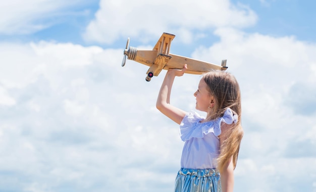 Travel by plane Keep dreaming kid play wooden toy airplane Study geography Dreams about travel Story about summer vacation small girl hold wooden plane imagination