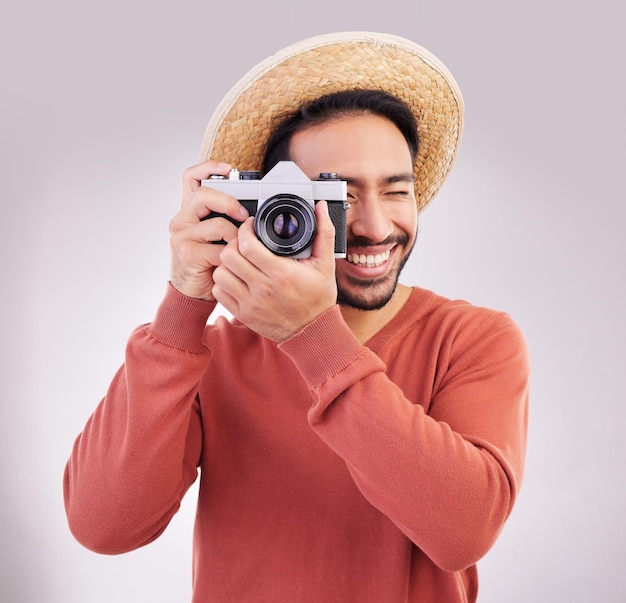 Travel camera and happy man on holiday adventure and fun on white background Smile travel and person taking picture photographer or tourist in studio for summer vacation journey and happiness