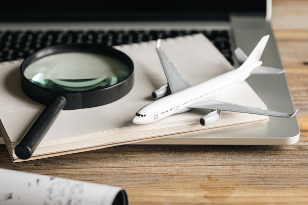 Фото Композиция путешествия с увеличительным стеклом самолета и картой на деревянном столе