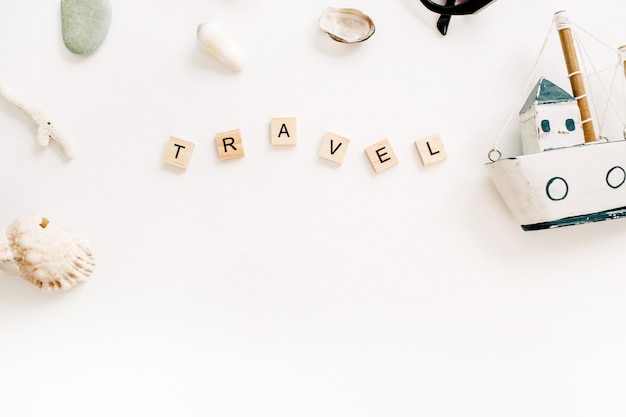 사진 장난감 보트, 흰색 표면에 조개와 여행 구성