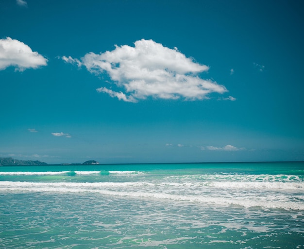 Concetto di viaggio spiaggia estate con nuvole e cielo blu