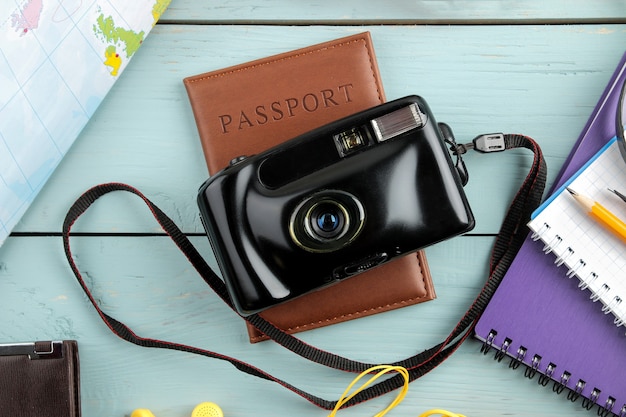 Travel concept camera, passport, map and shells on a blue wooden table. relaxation. holidays. top view