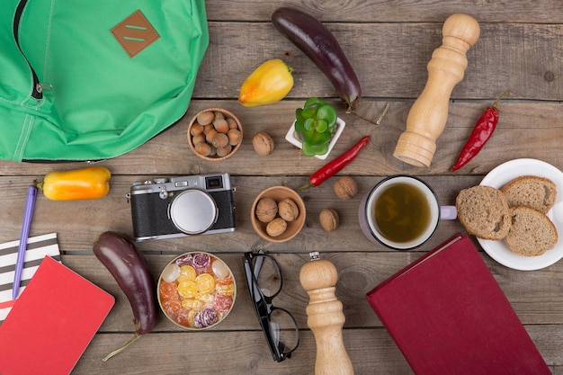 Foto concetto di viaggio tazza di tè fotocamera occhiali verdure accessori da cucina caramelle