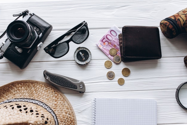 Photo travel concept,  documents, hat, compass, money, phone and camera on a white  background