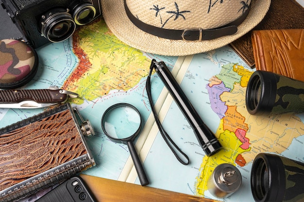 Travel concept geographical map magnifier and binoculars hat and camera travel background