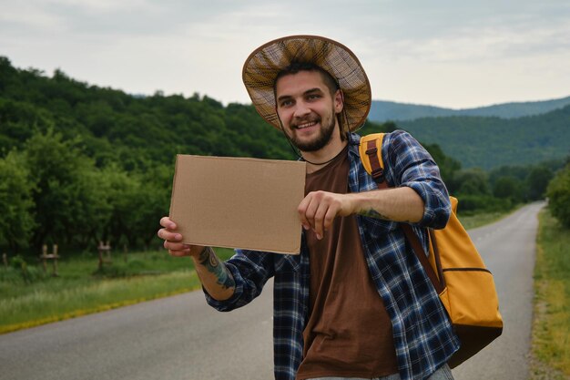 旅行のコンセプト男は通り過ぎる車を止めようとして一人で旅行に行きました