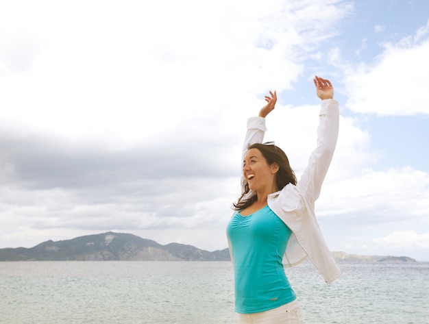 Travel concept - happy girl jumping on the beach, summer holiday.