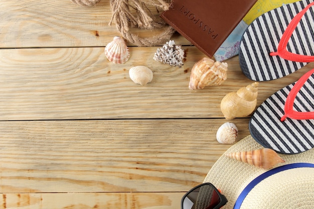 Travel concept Hat, flip flops and shells on a natural wooden table. relaxation. holidays. top view. free space