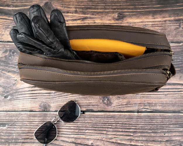 旅行のコンセプト - レザー バッグ。今日の若者の必需品のオーバーヘッド。メガネ、鍵、葉巻。