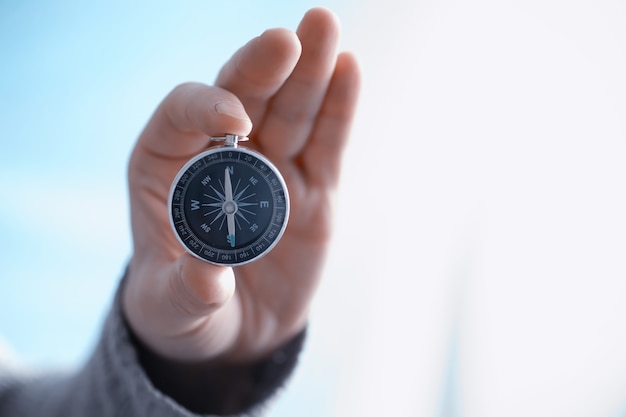 Travel concept. Magnetic compass in the hand. Retro navigator in hand a map and airplane background. Adventure Background.