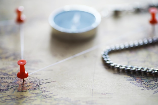 Photo travel concept map and needle with a marked place compass point on the map and routes