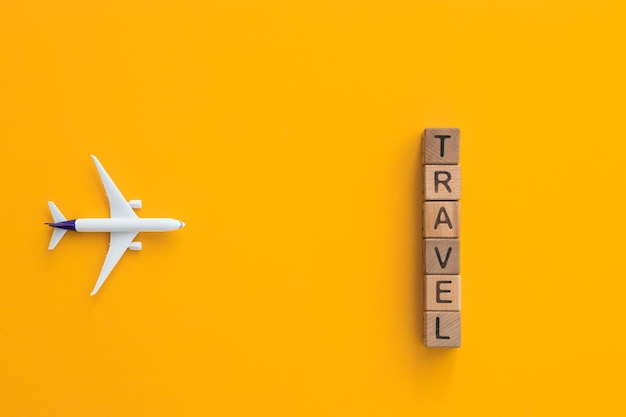 Фото Концепция путешествия на желтом фоне с копировальным пространством игрушка-самолет на желтом фоне
