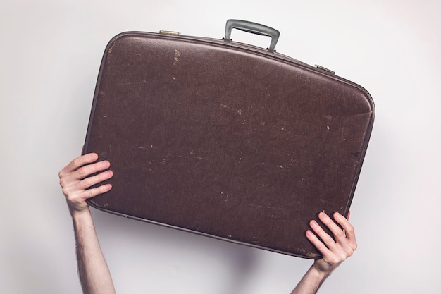 Travel concept Person holding a vintage travel suitcase