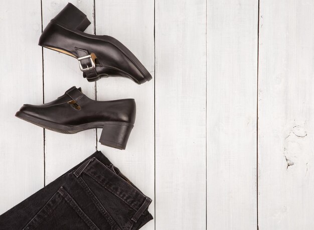 Travel concept shoes and jeans on white wooden desk