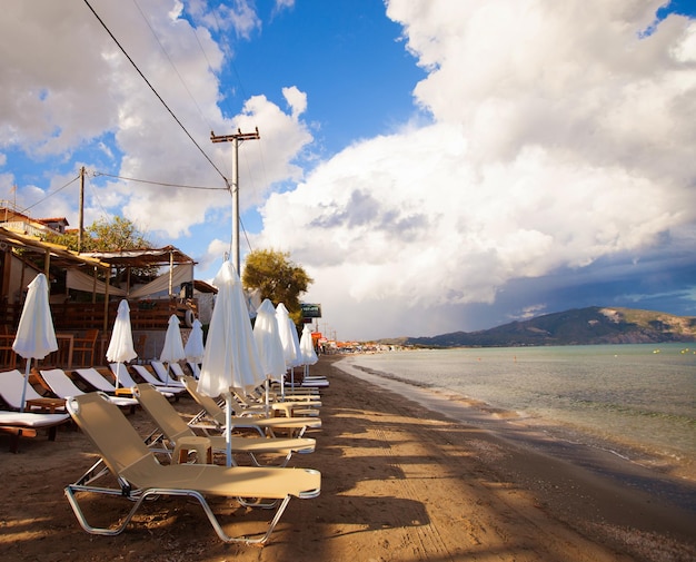 Travel concept sunchairs with umbrellas on beautiful beach Zakynthos island Greece