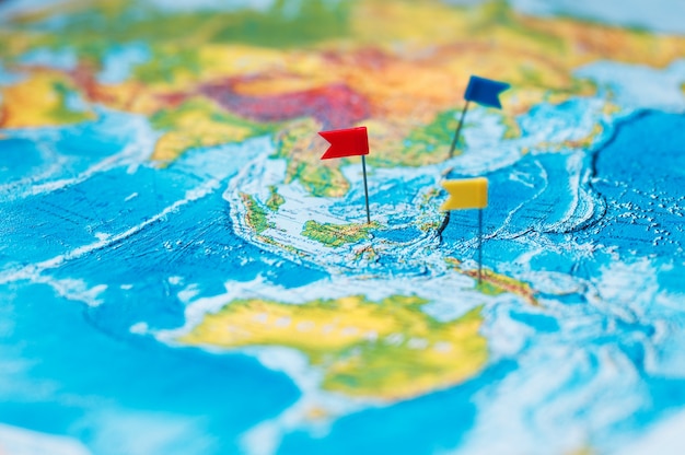 Photo travel concept with flag pushpins and world map.