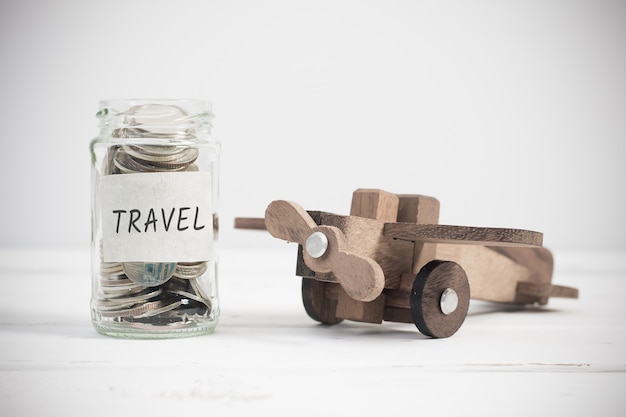 Travel concept with wooden airplane toy. Planning summer vacation, money budget trip concept.