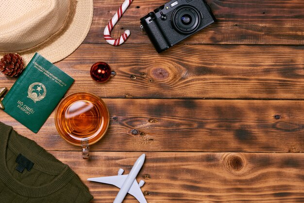 Travel concept on wooden table. Christmas decorations, camera, Vietnamese passport, clothes.