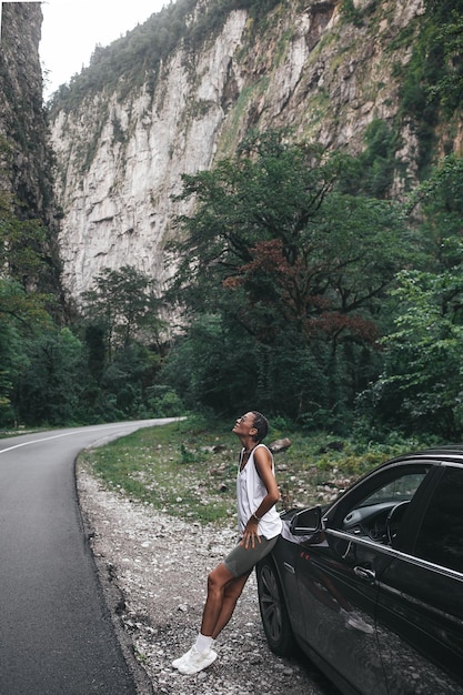 Concetto di viaggio giovane bella donna hipster viaggio in auto