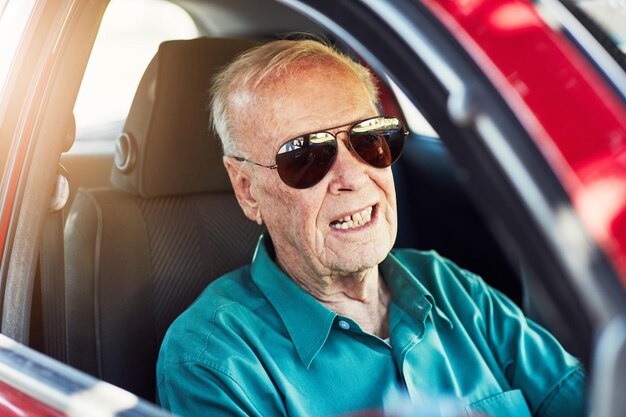 travel driving and senior man with sunglasses in car for journey destination or adventure in city retirement driver and elderly person in vehicle for road trip transportation or confidence