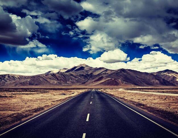 Travel forward concept background road on plains in Himalayas