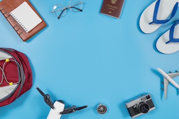 Travel gadgets and accessories on blue copy space in the middle