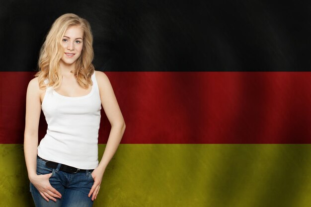 Путешествие по Германии концепция красивая блондинка на фоне флага Германии