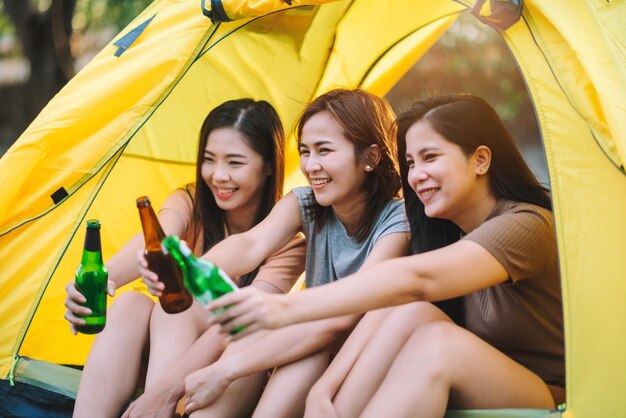 Travel group of diverse asian people enjoy camping tent with\
friends hang out party summer travel and recreation concept