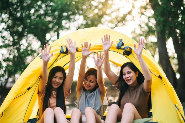 Travel group of diverse asian people enjoy camping tent with\
friends hang out party summer travel and recreation concept