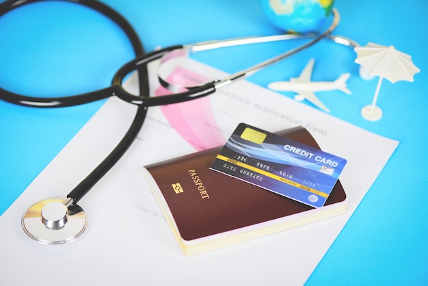 Travel insurance application form with passport, credit card and stethoscope