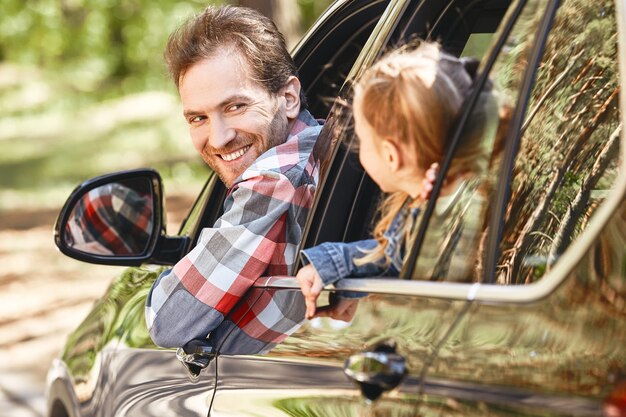 Foto viaggiare è vivere padre e figlia guardando fuori dal finestrino e sorridendo