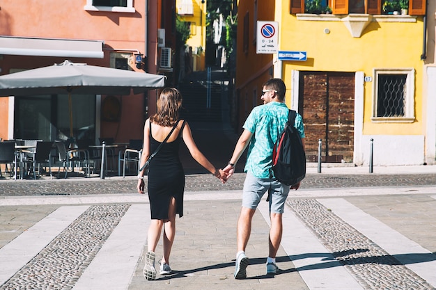 Travel Italy. Lovers in Verona with italian streets and cafe in the background.