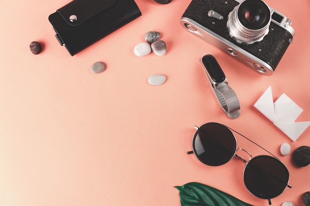 Travel items on a pink background