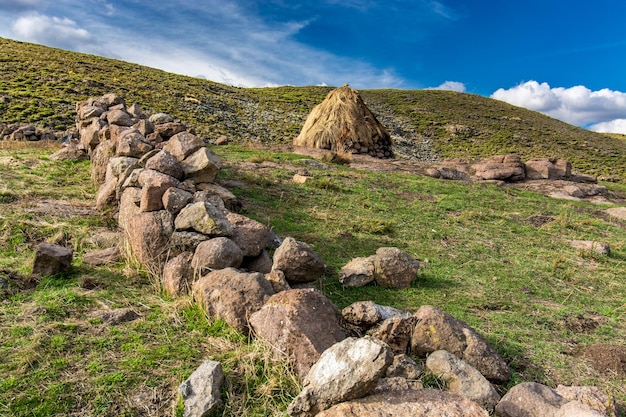 Travel to Lesotho A rondavel the traditional hut of Basotho shepherds behind an old stone wall