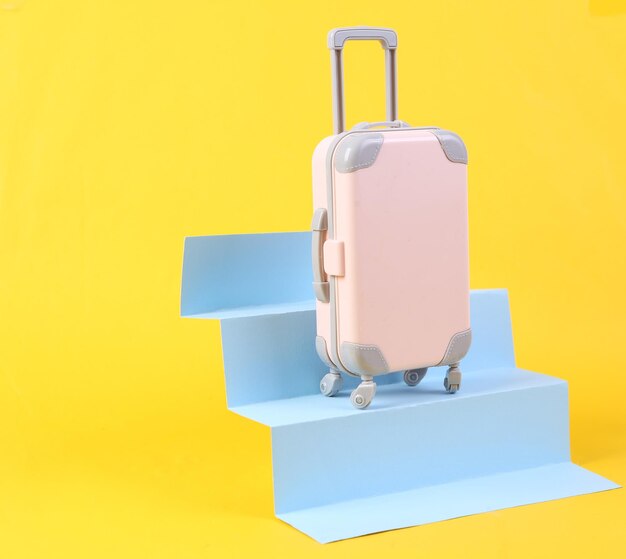 Travel luggage on stairs yellow background Concept art minimalism