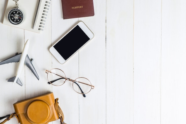 Viaggio oggetti flatlay su legno bianco con spazio di copia