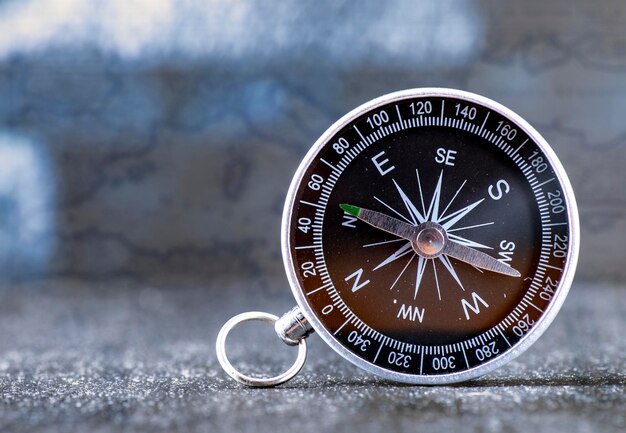 Travel planning navigation concept classic black magnetic\
detail of compass on light blue backround