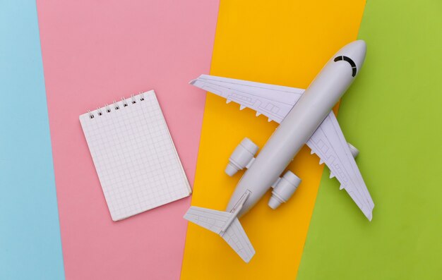 Travel planning. Toy air plane and notebook