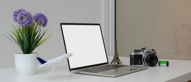 Travel preparation concept with blank screen laptop, camera, travel accessories and decoration